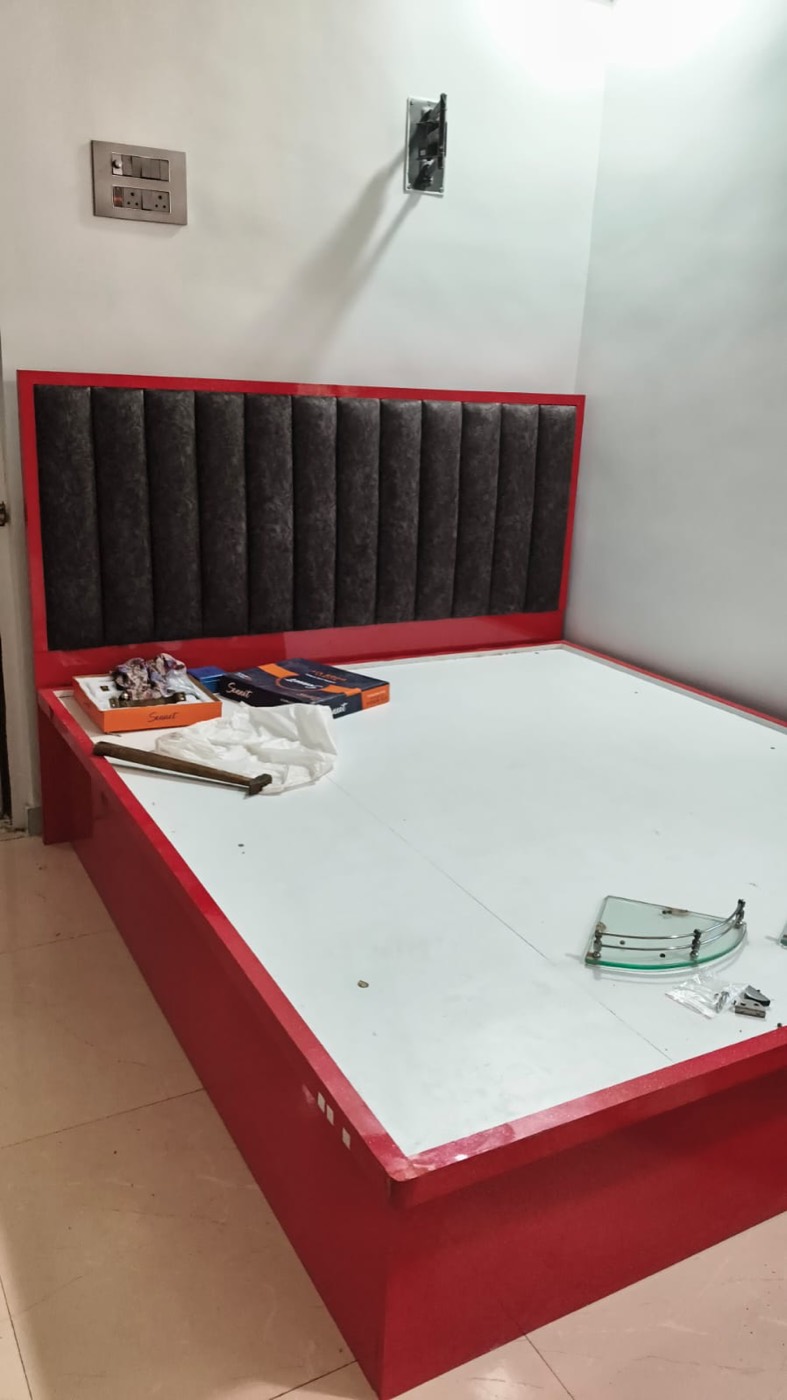 Red high-gloss bed with grey tufted headboard panel.